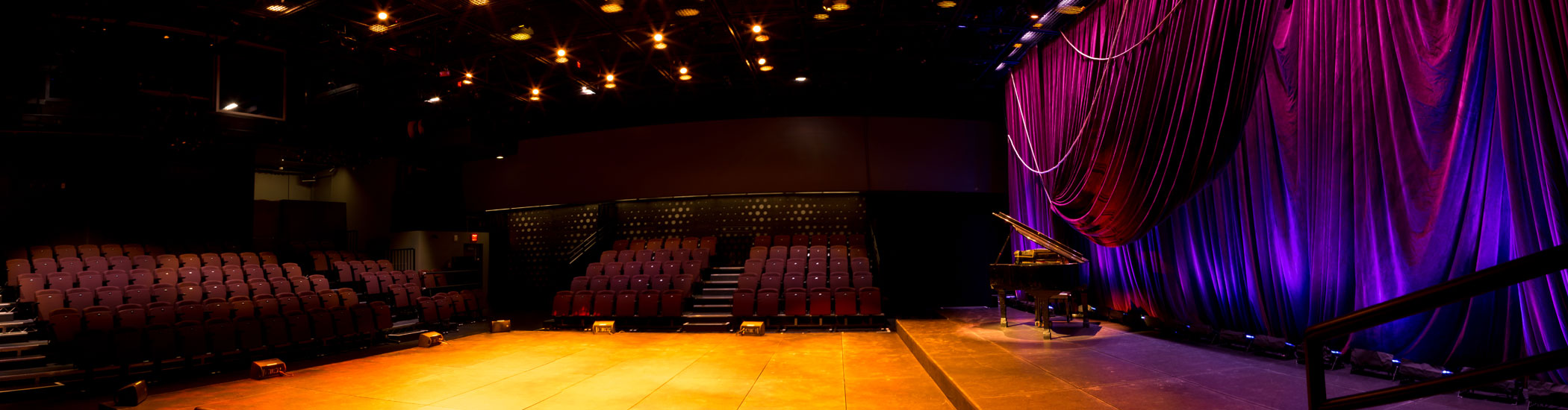 Photo of the Newmont Stage at the BMO theatre Centre interior. Onstage is a grand piano and the room is empty.